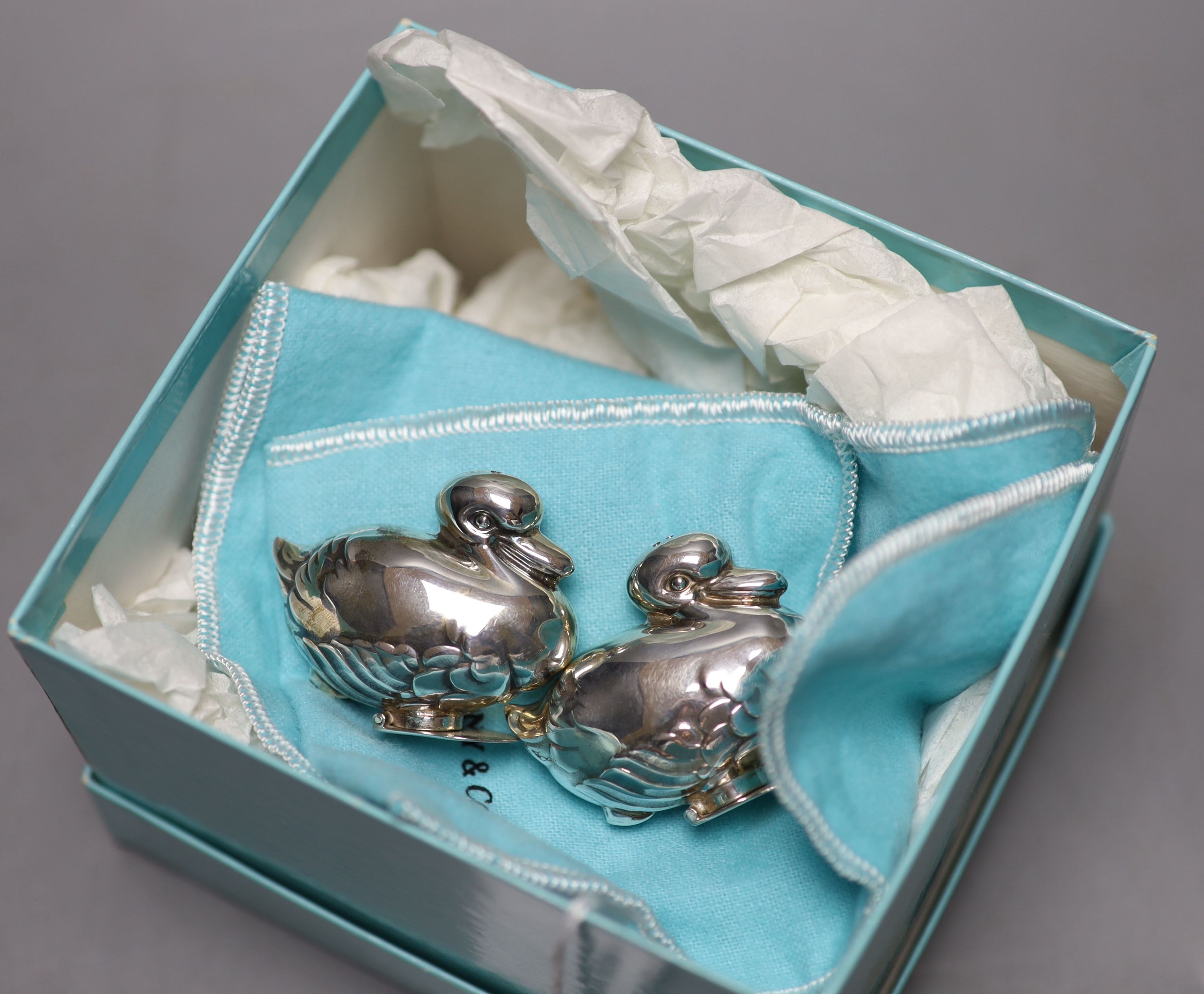 A modern pair of Tiffany & Co novelty silver condiments, modelled as a pair of ducks, height 4cm, with original box etc. import marks for London, 1990.